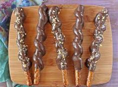 four chocolate covered donuts on a wooden plate