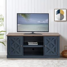 a flat screen tv sitting on top of a wooden stand