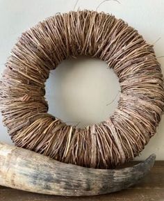 a wreath made out of twigs and an animal's horn is sitting on a table