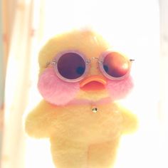 a yellow stuffed animal with sunglasses on it's face and pink fur around its neck