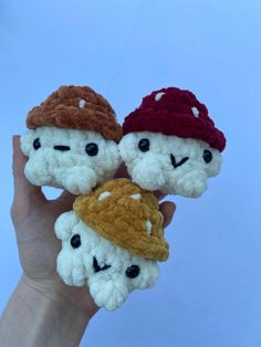 three small crocheted amigurma dolls are held in the palm of a hand