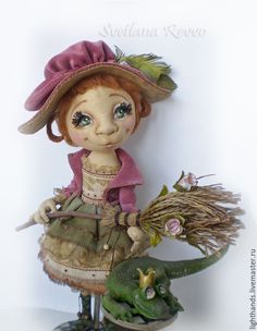 a small doll is standing next to a fake lizard and holding a planter with it's head