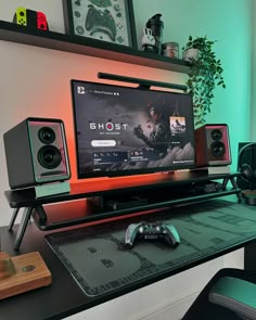 a computer monitor sitting on top of a desk next to speakers and a mouse in front of it