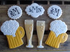 decorated cookies are arranged in the shape of wine glasses and champagne flutes on a pallet