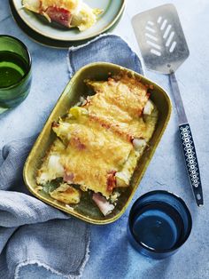 a casserole dish with ham and cheese in it on a blue table cloth