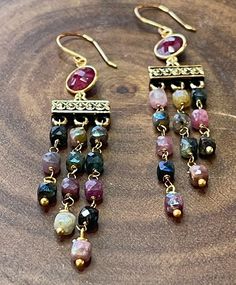 These earrings are colorful with beautiful cube shape tourmalines that coated for some shimmer. They are truly a gorgeous arrangement of colors. The bezel connectors are ruby. All metal components are gold filled, gold plated, and non-tarnish gold brass. These earrings are 3.25"long. Peridot Earrings, Ruby Beads, Aqua Chalcedony, Strawberry Quartz, Quartz Earrings, Fringe Earrings, Morganite, Labradorite, Tourmaline