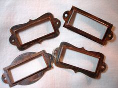 four old metal frames sitting on top of a white cloth covered table next to each other