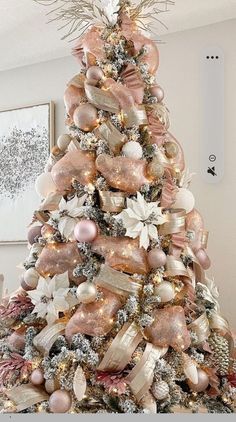 a christmas tree decorated with pink and gold ornaments