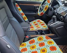 the interior of a car is decorated with sunflowers and crocheted seats