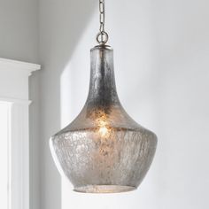 a light fixture hanging from a ceiling in a room with white walls and window sill