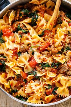 a pot filled with pasta and meat on top of a wooden table