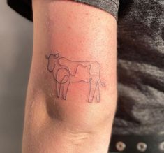 a person with a cow tattoo on their arm