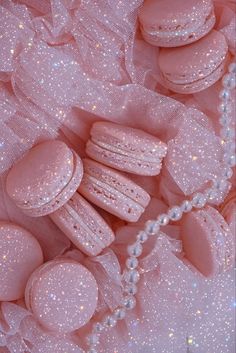 pink macaroons and pearls are scattered around the fabric, as if it were sequins