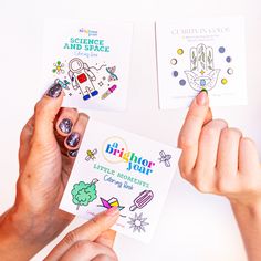 two hands holding small cards that say, science and space with little moments coloring book