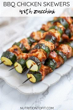 bbq chicken skewers with zucchini on a white plate and text overlay