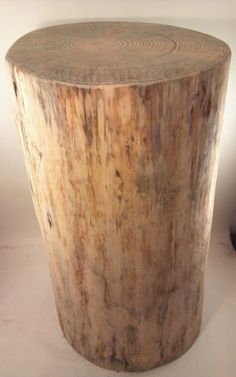 a round wooden table sitting on top of a white floor