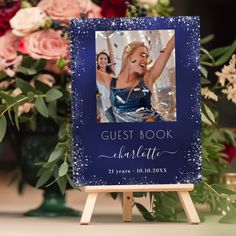 the guest book is on top of a easel next to some flowers and candles