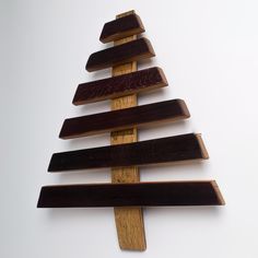 a wooden christmas tree is hanging on the wall