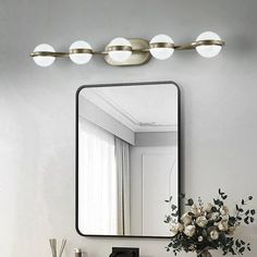 a bathroom vanity with a mirror and flowers on it