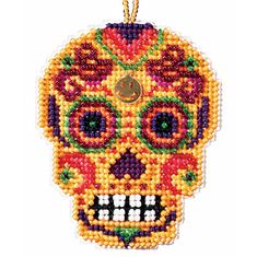 a beaded sugar skull ornament hanging on a string with a gold chain