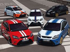 four different colored cars are parked in a parking lot with white and blue stripes on them