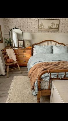 a bedroom with a bed, dresser and mirror