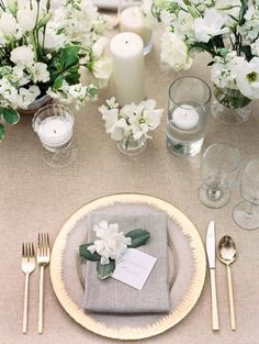 black and white photo of table setting with flowers, candles, napkins and silverware