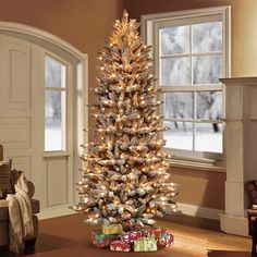 a decorated christmas tree in a living room with presents on the floor next to it