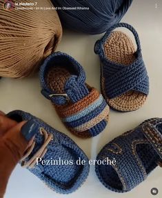 crocheted baby shoes and balls of yarn on a table