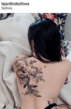 a woman laying on top of a bed covered in tattoos