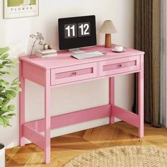 a pink desk with a computer on it