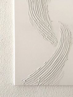 a piece of art that looks like it is made out of white paper and has wavy lines