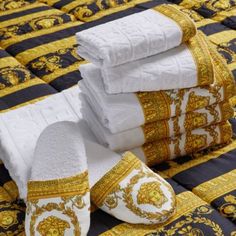 towels and slippers are stacked on top of each other in an elaborately designed bed