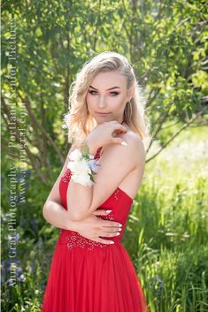 a young woman in a red dress posing for a photo with her hands on her chest