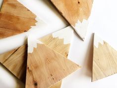 several pieces of wood with white paint on them sitting next to each other in the shape of triangles