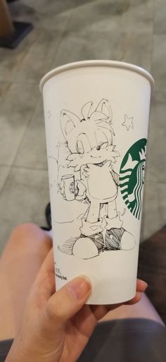 someone holding up a starbucks cup with an image of sonic the hedgehog on it