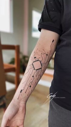 a person with a tattoo on their arm holding onto a piece of electronic circuit board