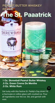 a bottle of whiskey sitting next to some gold coins and a glass filled with green liquid