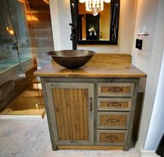 a bathroom with a sink, mirror and wooden cabinet