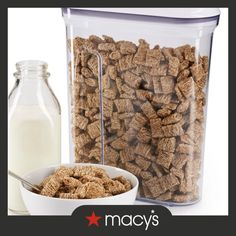 a glass container filled with cereal next to a bottle of milk