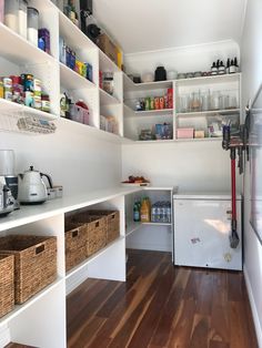 a kitchen with white cabinets and wooden floors