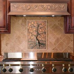 a stove top oven sitting inside of a kitchen next to wooden cupboards and a painting on the wall