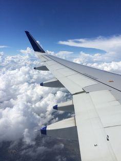 the wing of an airplane flying high above the clouds