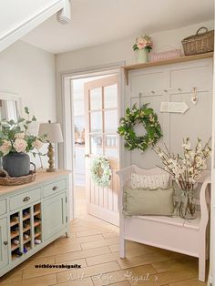 the entryway is decorated with wreaths, flowers and greenery for springtime