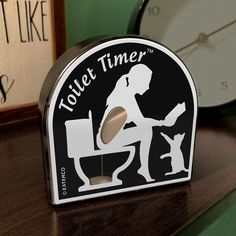 a clock that is sitting on top of a table next to a sign for toilet time