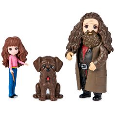 three toy figurines of people and a dog, one with long red hair