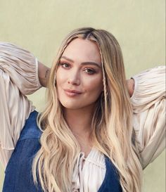 a woman with long blonde hair posing for the camera