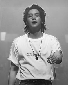 black and white photograph of a woman with her eyes closed wearing a t - shirt