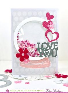 a close up of a card on a table with flowers and hearts in the background