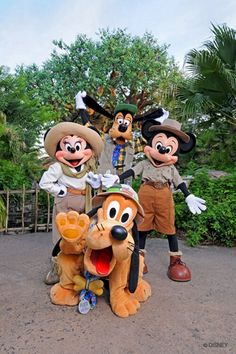 three goofy and mickey mouse characters posing for a photo